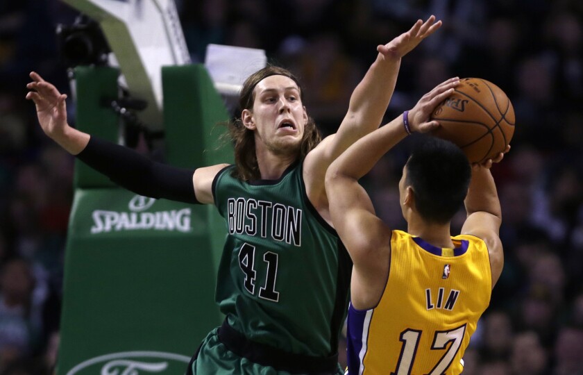 Lakers point guard Jeremy Lin has his shot challenged by Celtics center Kelly Olynyk in the first half.