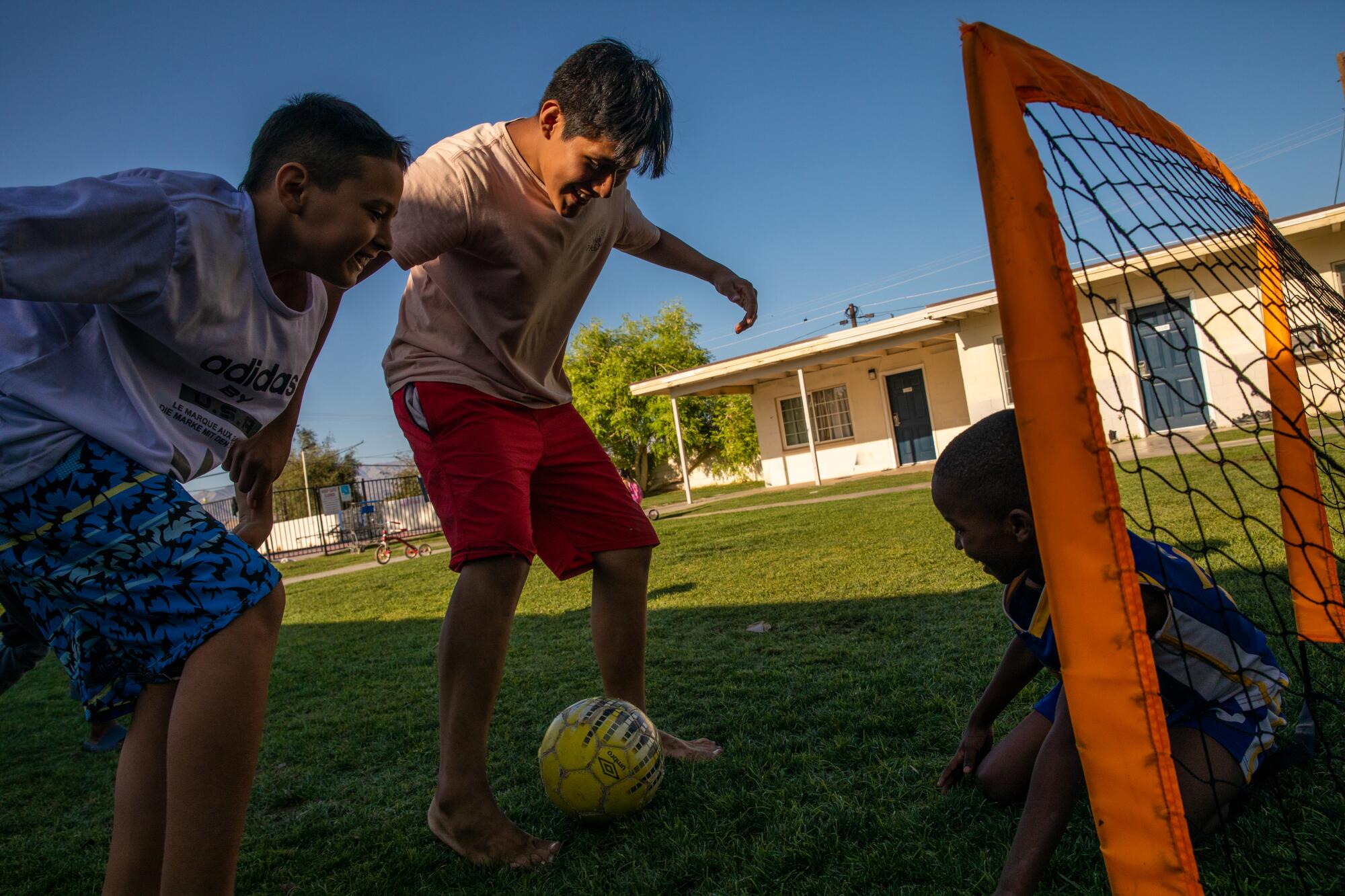 Children of asylum seeking families of different nationalities play soccer at the shelter.