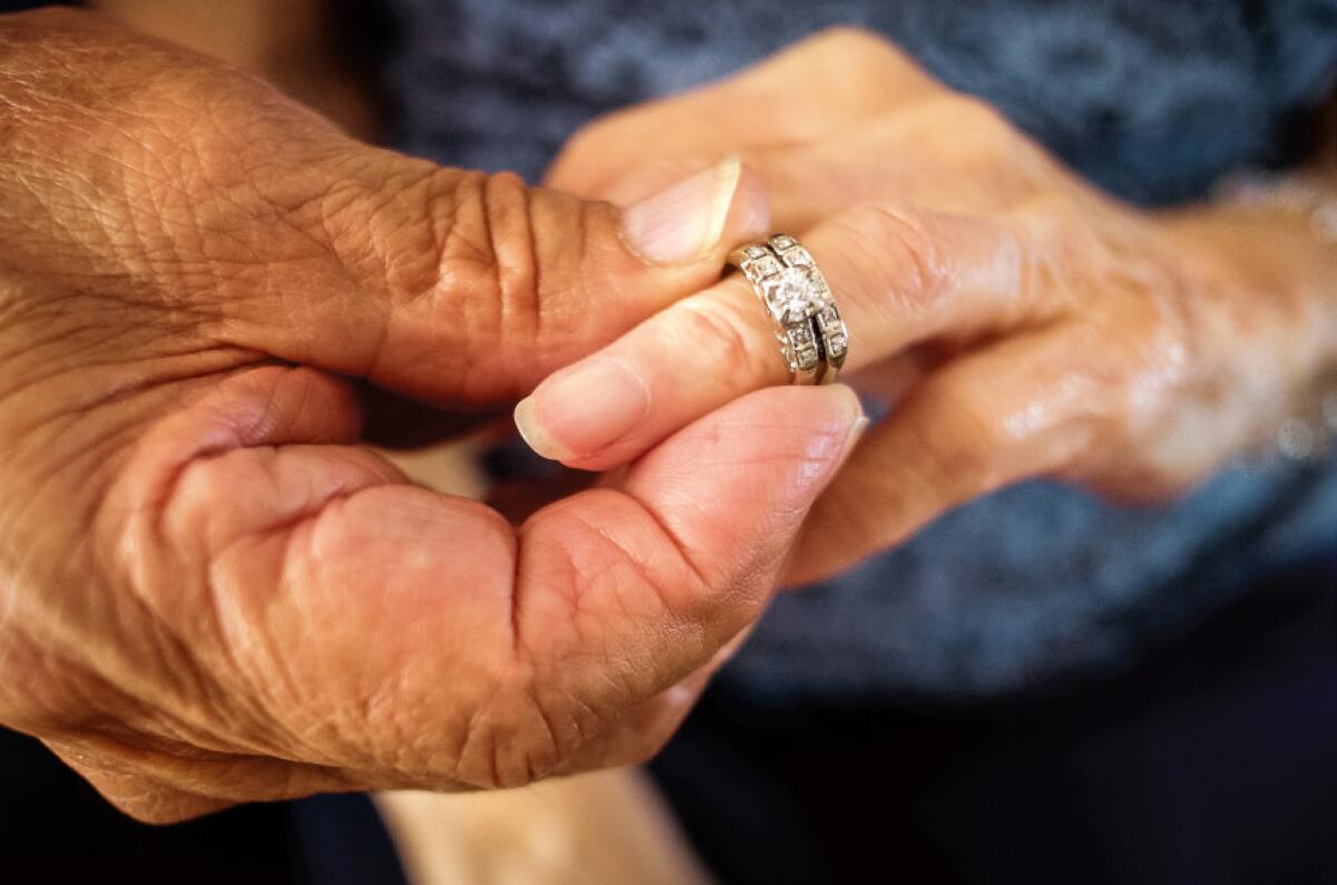 Robert Kirker pone un anillo de bodas que estuvo perdido 50 años en la mano de su esposa Ofelia en la casa donde viven en Las Cruces, Nuevo México.