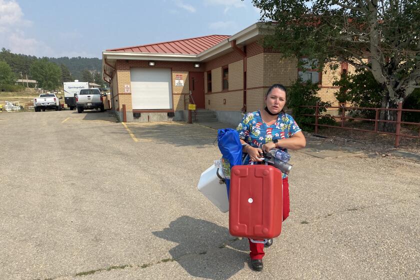 Nurse carries coolers containing vaccines