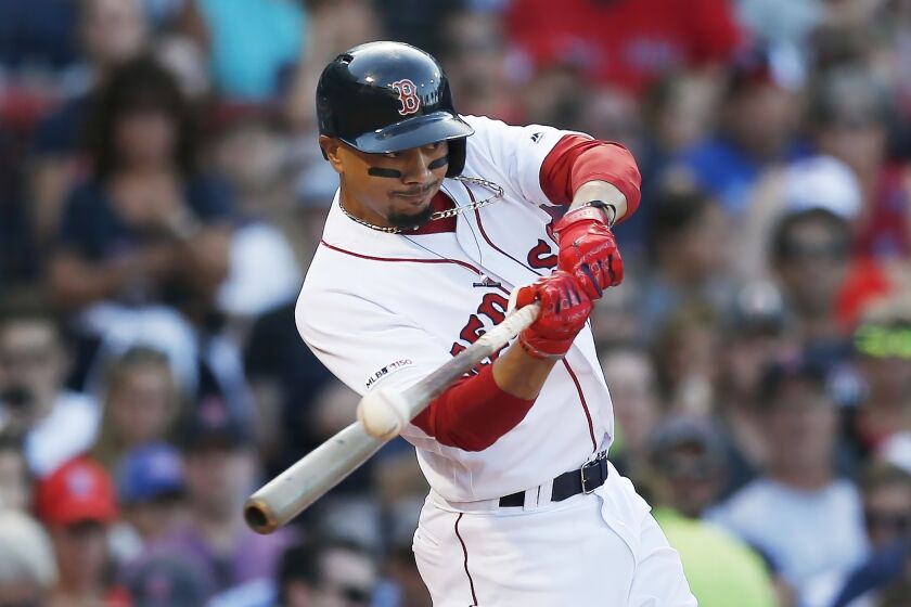 FILE - In this Aug. 10, 2019, file photo, Boston Red Sox's Mookie Betts hits an RBI-double during the sixth inning of a baseball game against the Los Angeles Angels in Boston. Betts has agreed to a $27 million contract with the Red Sox. It is the largest one-year salary for an arbitration-eligible player. (AP Photo/Michael Dwyer, File)