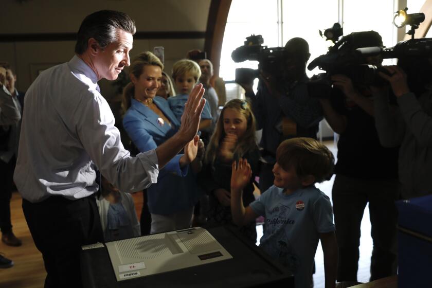 Lt. Gov. Gavin Newsom gets a high-five from his son, Hunter, 6, after casting his ballot in the Calif. primary election with his wife, Jennifer Siebel Newsom, and children; Brooklynn, 4, Montana, 8, and Dutch, 2, at the Masonic Lodge Fairfax in Larkspur.