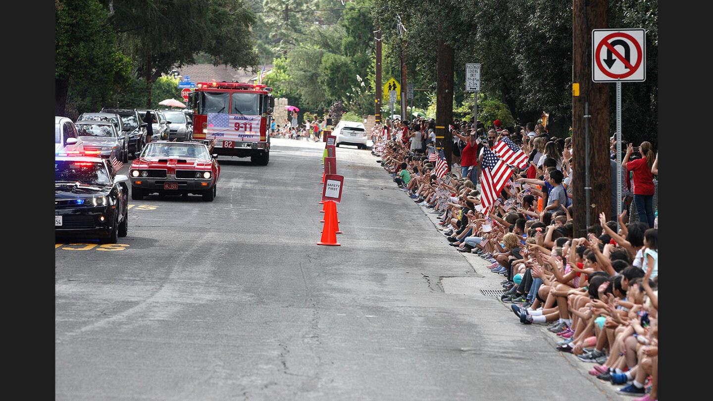 All Monte Vista Elementary School students sat on the curb to yell and wave American Flags for the Crescenta Valley Remembrance Motorcade on Monday, Sept. 11, 2017, the 16th year after the terrorist attacks in New York City. The parade, with fire trucks, police cars, hot rods and antique cars, drove a route that passed every school in La Crescenta and La Cañada, and every fire department as well. Several of the vehicles displayed the names of the 343 firefighters that lost their lives on September 11, 2001.