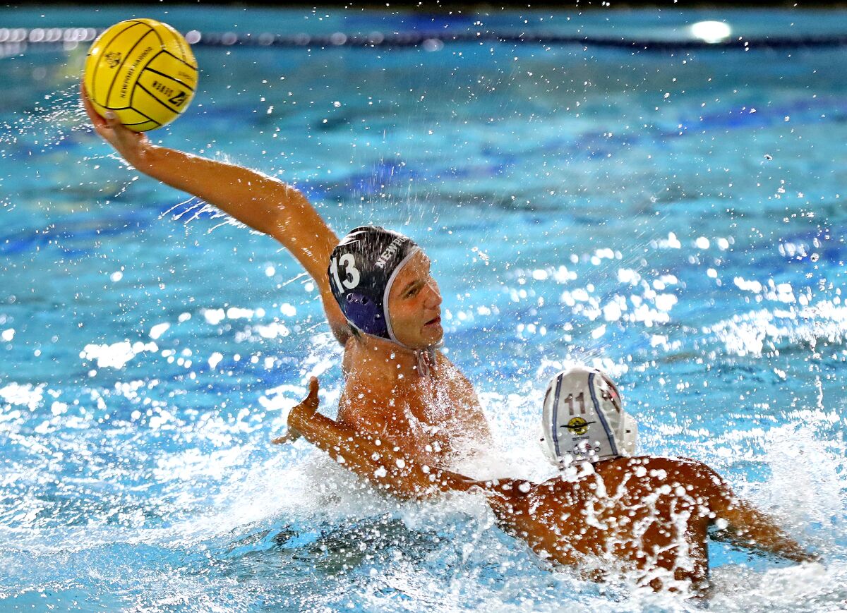 Newport Harbor's Ben Liechty (13) shoots and scores in front of the net during Friday night's Battle of the Bay game.