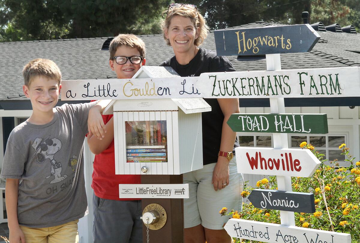La Canada resident Billie Melillo with sons Colin, 12, and Spencer, 12, next to a tiny free book lending library she built outside her home. Photographed on Tuesday, August 18, 2015.