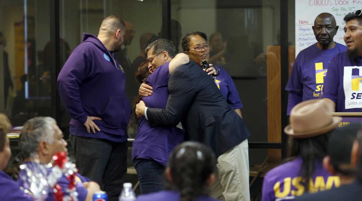 Blanca Flores hugs U.S. Rep. Xavier Becerra (D-Los Angeles), center, at a rally with Service Employees International Union volunteers in Las Vegas. Becerra and L.A. Mayor Eric Garcetti spoke at the Feb. 13 event.