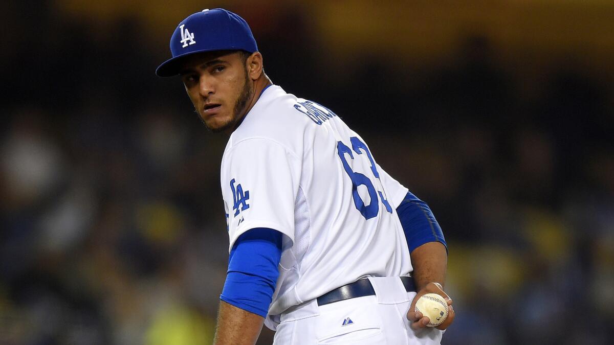 Dodgers reliever Yimi Garcia checks the runner at first base before delivering a pitch during a game against the San Diego Padres back in April.