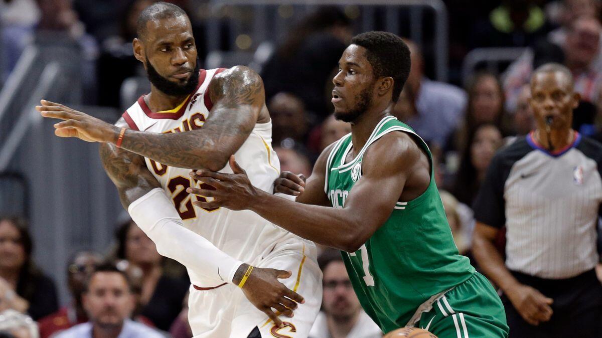 Cleveland Cavaliers' LeBron James, left, passes against Boston Celtics' Semi Ojeleye in the first half on Tuesday.