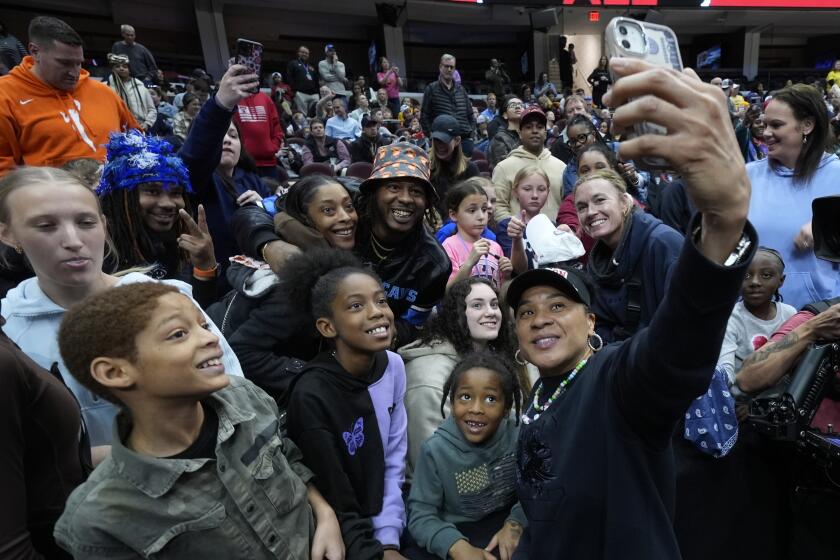 South Carolina head coach Dawn Staley takes a selfie with fans during practice for the NCAA Women's Final Four championship basketball game Saturday, April 6, 2024, in Cleveland. (AP Photo/Morry Gash)