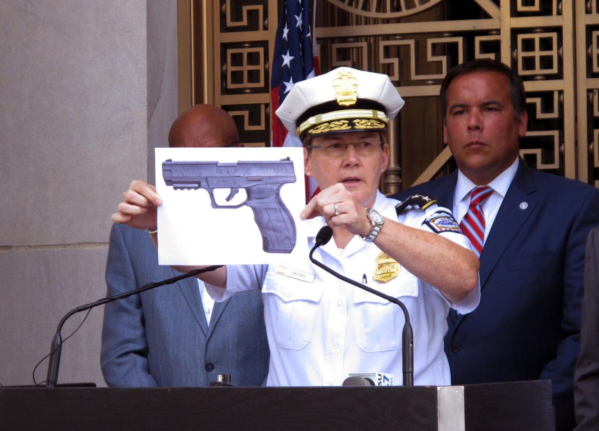 Columbus, Ohio, Police Chief Kim Jacobs holds a photo showing the type of BB gun that police say a 13-year-old boy pulled from his waistband just before he was shot and killed by police.