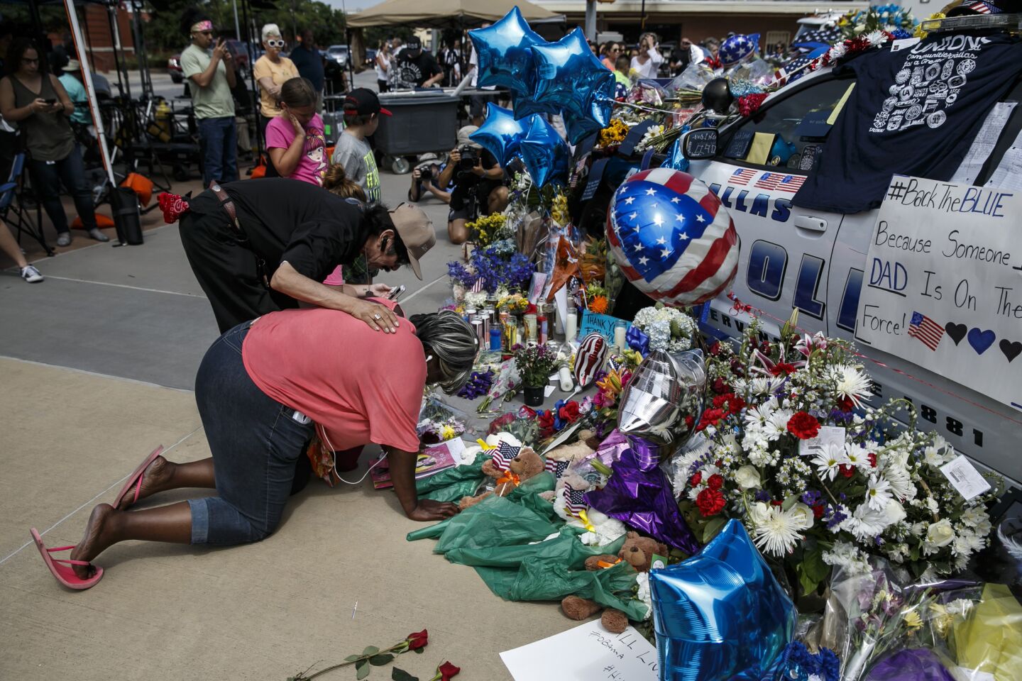 Djuana Franklin is consoled by a passerby as she weeps at the memorial for slain police officers in Dallas.