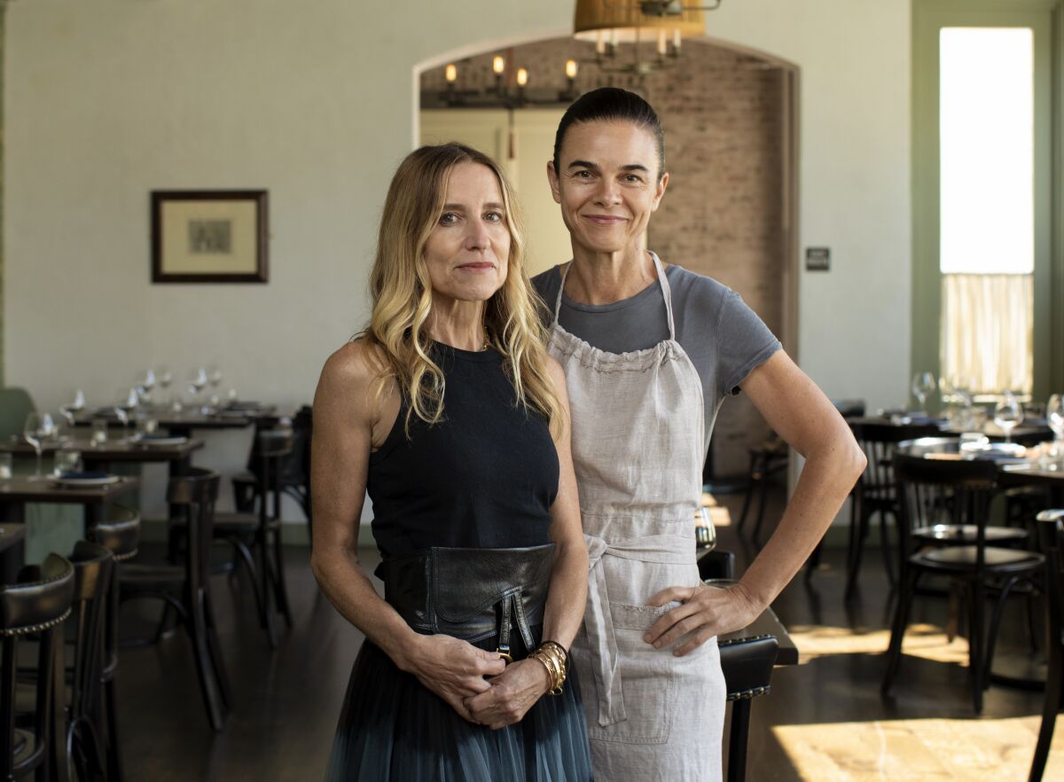 Caroline Styne, left, and Suzanne Goin, wearing an apron, stand in a restaurant dining room