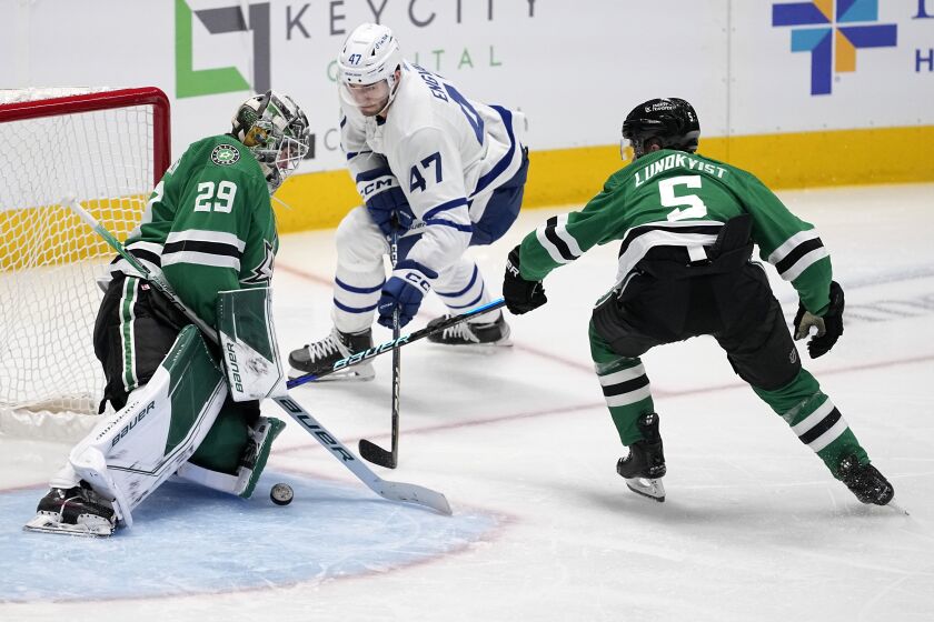 Dallas Stars goaltender Jake Oettinger (29) blocks a shot by Toronto Maple Leafs left wing Pierre Engvall (47) as defenseman Nils Lundkvist (5) helps defend on the play in the second period of an NHL hockey game, Tuesday, Dec. 6, 2022, in Dallas. (AP Photo/Tony Gutierrez)