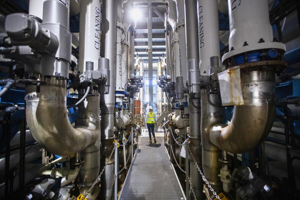 Michelle Peters, compliance manager for Poseidon Water, walks through the reverse osmosis desalination plant in Carlsbad.