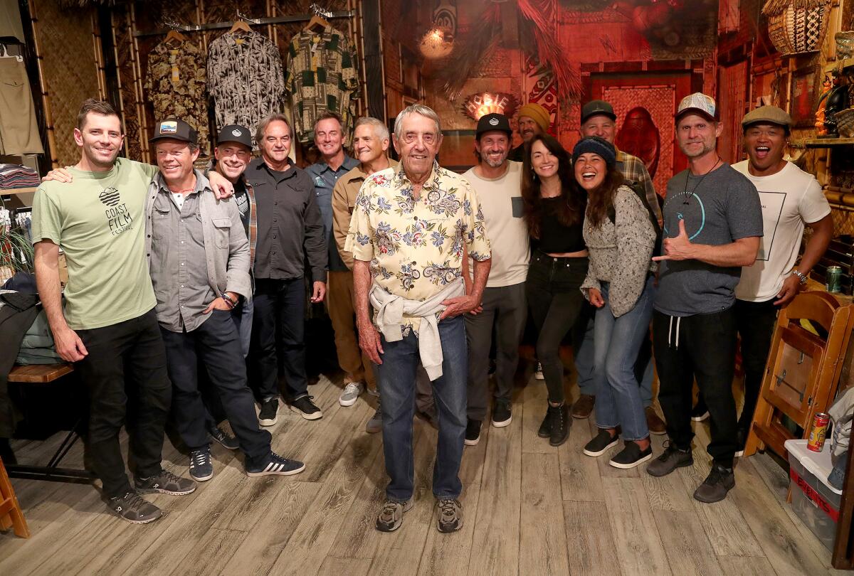 Dick Metz, center, stands with a host of supporters on opening night of the Coast Film Festival at Hobie Surf Shop.