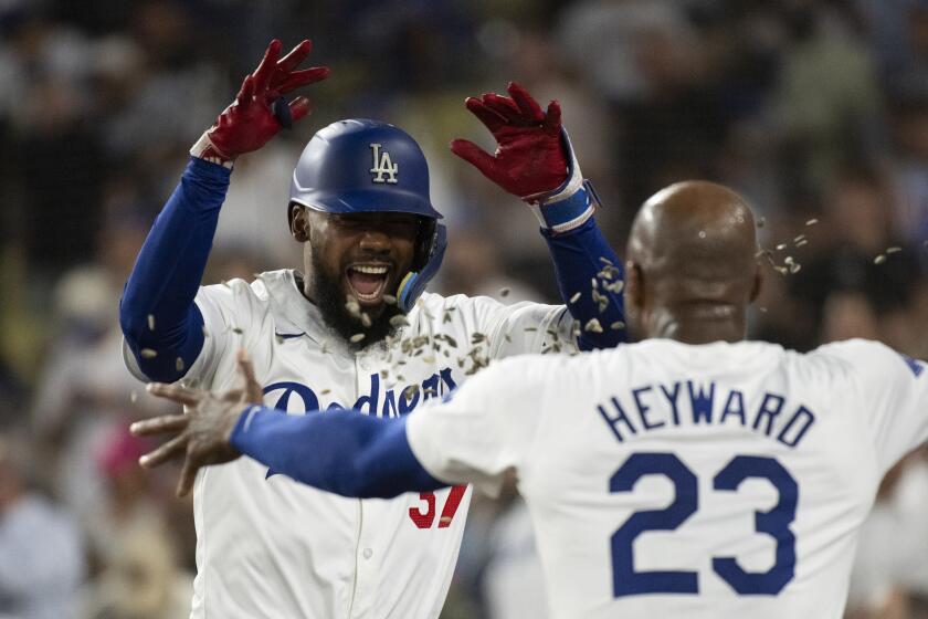 Jason Heyward (23) lanza pipas a su compañero en los Dodgers de Los Ángeles Teoscar Hernández tras su jonrón de dos carreras en el tercer inning del juego de la MLB que enfrentó a su equipo con los Filis de Filadelfia, en Los Ángeles, el 5 de agosto de 2024. (AP Foto/Kyusung Gong)