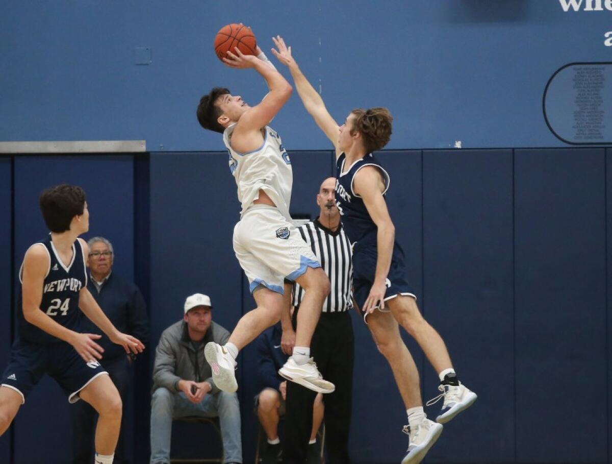 Corona del Mar’s Jack Stone steps back for a jumper over Newport Harbor’s Ryan Miller in the Battle of the Bay game on Jan. 17.