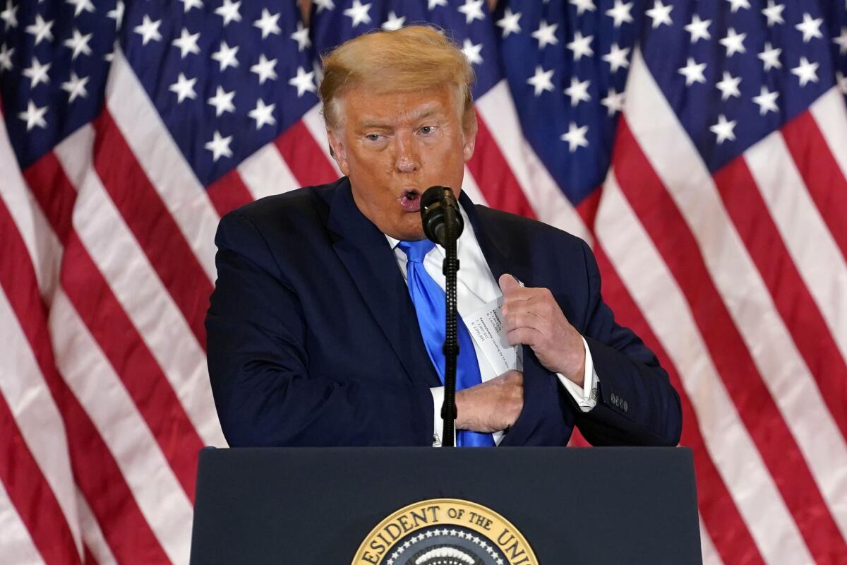 President Trump pulls notes from his jacket pocket as he speaks at the White House early Wednesday morning.