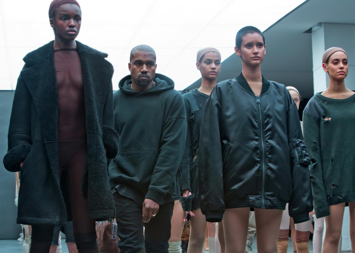Kanye West, second from left, appears with models during the showing of the Kanye West Adidas collection.