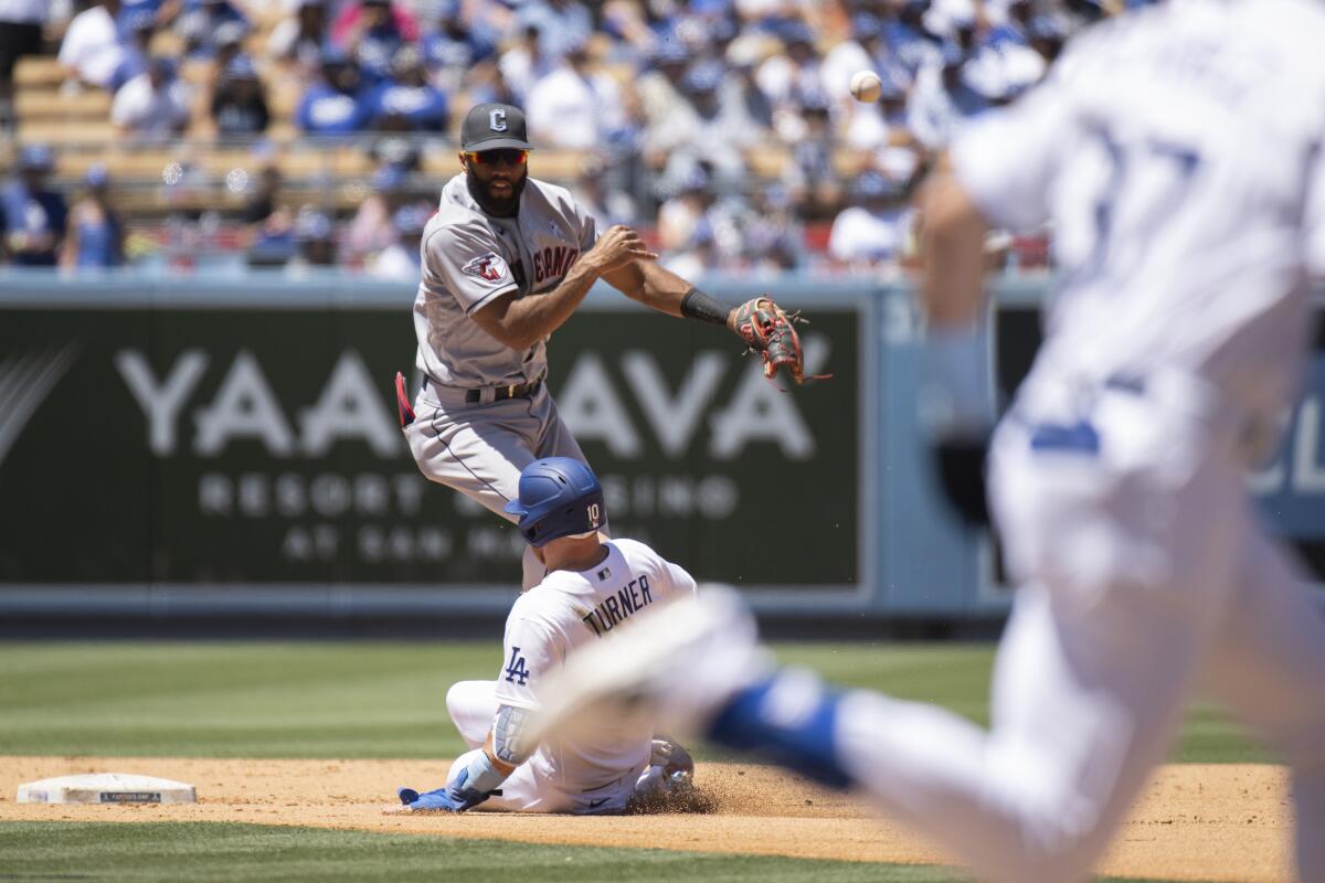 Cleveland Guardians shortstop Amed Rosario turns a double play over Dodgers baserunner Justin Turner.