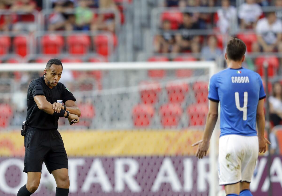 Referee Ismail Elfath, left, discusses a call with Italy's Matteo Gabbia during U20 World Cup qualifying match.