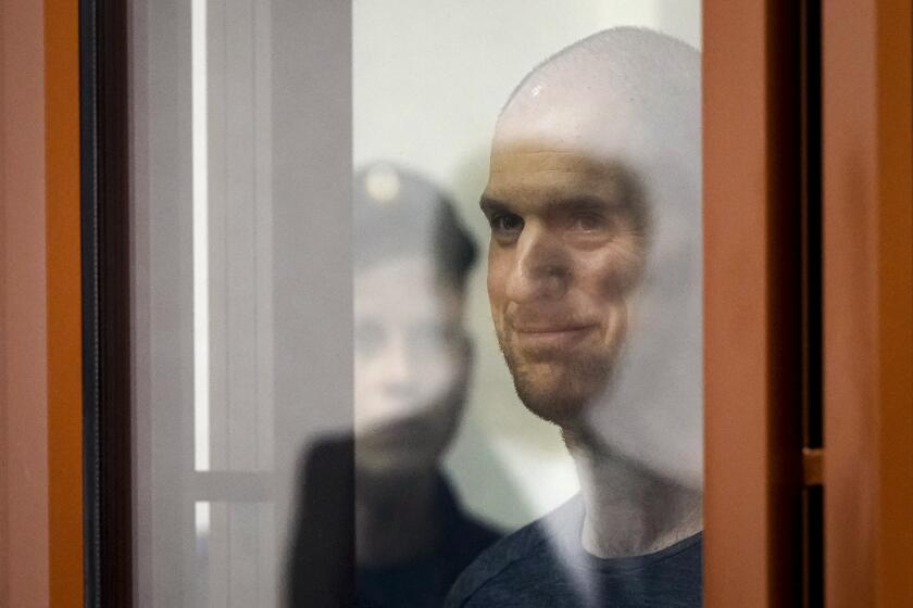Wall Street Journal reporter Evan Gershkovich stands listening to the verdict in a glass cage of a courtroom inside the building of "Palace of justice," in Yekaterinburg, Russia, on Friday, July 19, 2024. A Russian court convicted Gershkovich on espionage charges that his employer and the U.S. have rejected as fabricated. He was sentenced to 16 years in prison after a secretive and rapid trial in the country's highly politicized legal system. (AP Photo/Dmitri Lovetsky)