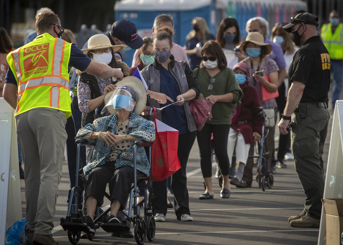 People lined up for the COVID-19 vaccine at Disneyland have their temperatures taken last week.