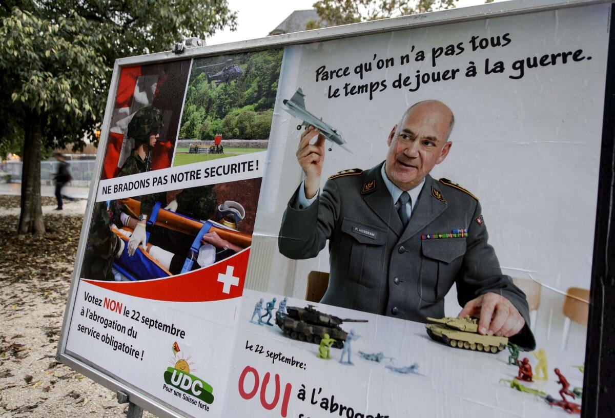 Rival campaign posters stand side by side ahead of Switzerland's vote Sunday that defeated a pacifist group's referendum proposing to end Swiss Army conscription.