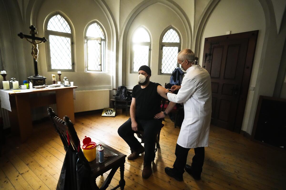 A doctor gives a man a vaccination against coronavirus inside the St. Petri church in Chemnitz, Germany