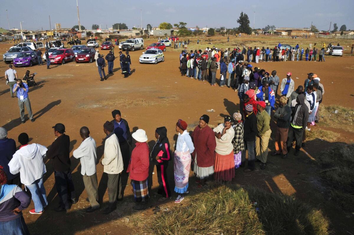 People line up at the entrance of a Bekkersdal, South Africa, polling station to cast ballots in a national election.