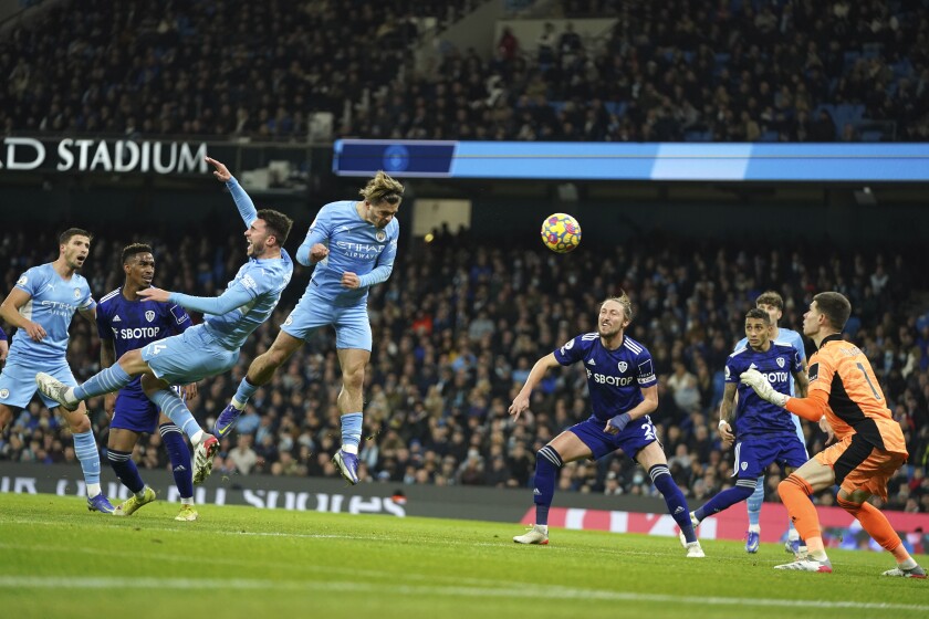 Manchester City's Jack Grealish, centre, scores his side's second goal during the English Premier League soccer match between Manchester City and Leeds United at Etihad stadium in Manchester, England, Tuesday, Dec. 14, 2021. (AP Photo/Jon Super)