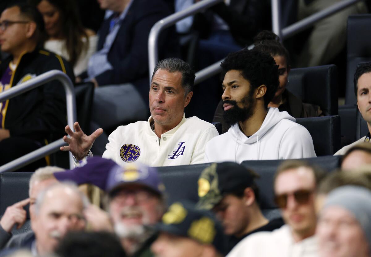 Lakers general manager Rob Pelinka sits with and talks to Spencer Dinwiddie at Crypto.com Arena.