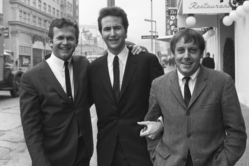 FILE - In this Jan. 31, 1967, file photo, members of the Kingston Trio, from left: Bob Shane, John Stewart and Nick Reynolds are pictured in the Hollywood section of Los Angeles. Shane, the last surviving original member of the popular folk group the Kingston Trio and the lead singer on its million-selling ballad “Tom Dooley” and many other hits, died Sunday, Jan. 26, 2020, in Phoenix. He was 85. (AP Photo/File)