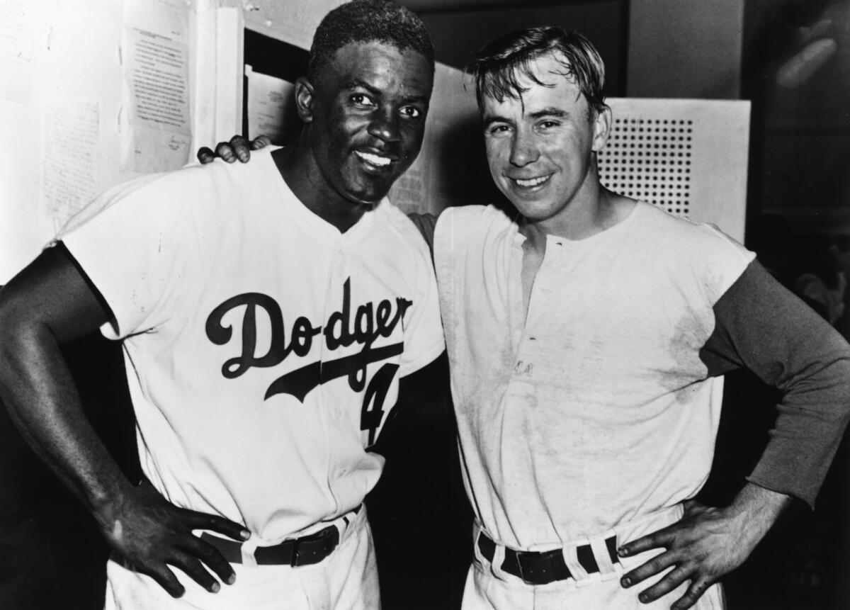 Pee Wee Reese stands with Jackie Robinson.