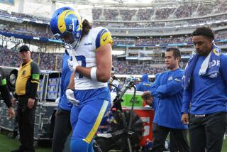 Rams receiver Luka Nacua walks off the field holding his side after suffering an injury against the Browns.
