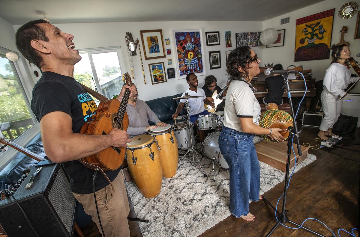 Quetzal members play instruments in the middle of a living room. 