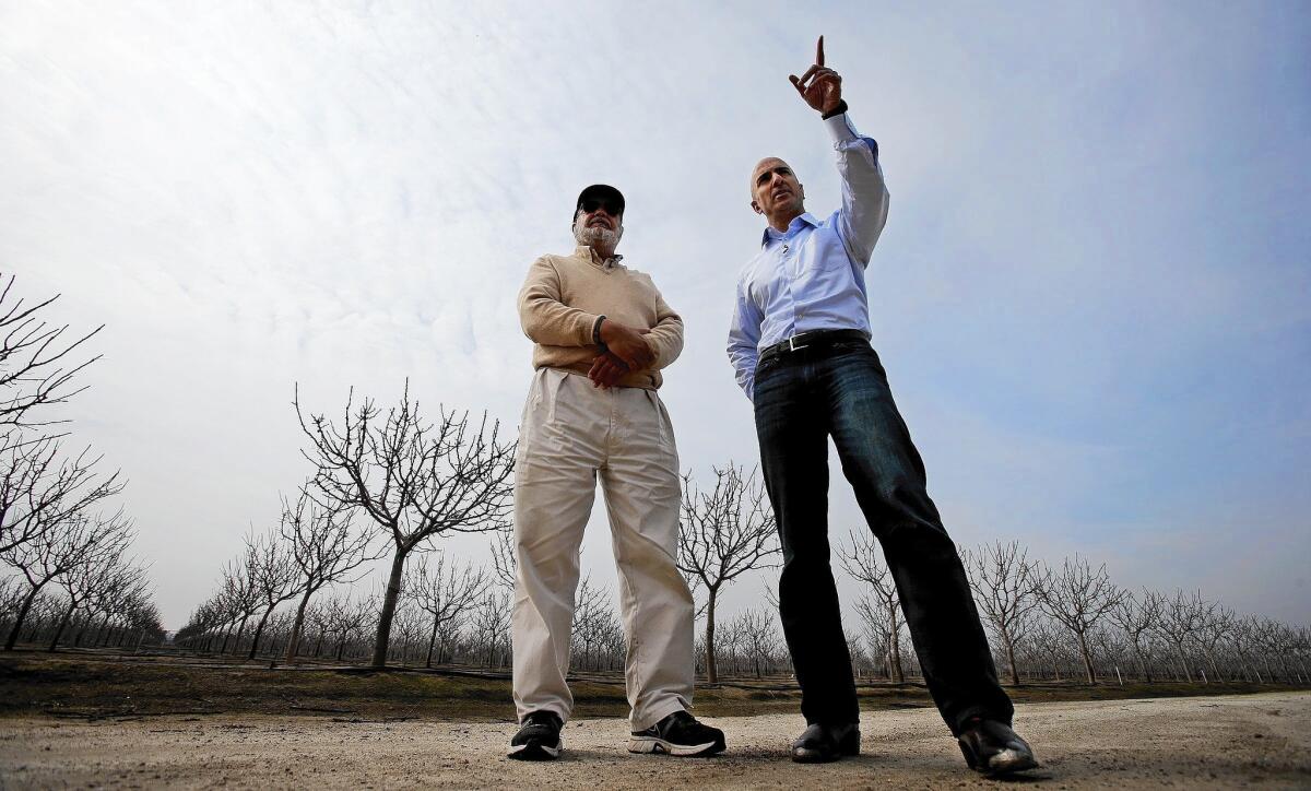 Neel Kashkari, right, a Republican who is running for governor of California, talks with Bir Dhillon, owner of Khalsa Farms, at Dhillon's pistachio grove on the outskirts of Delano in Kern County.
