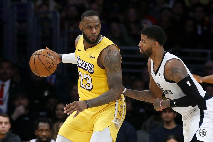 Los Angeles Lakers' LeBron James (23) is defended by Los Angeles Clippers' Paul George (13) during an NBA basketball game between Los Angeles Lakers and Los Angeles Clippers, Wednesday, Dec. 25, 2019, in Los Angeles. The Clippers won 111-106. (AP Photo/Ringo H.W. Chiu)