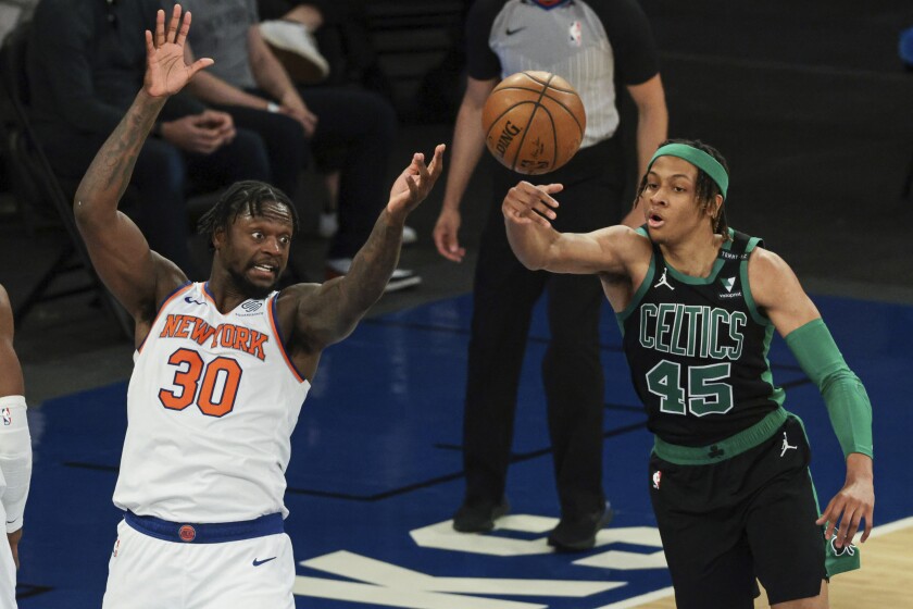 Boston Celtics guard Romeo Langford (45) deflects the ball away from New York Knicks forward Julius Randle (30) during the second half of an NBA basketball game in New York, Sunday, May 16, 2021. (Vincent Carchietta/Pool Photo via AP)