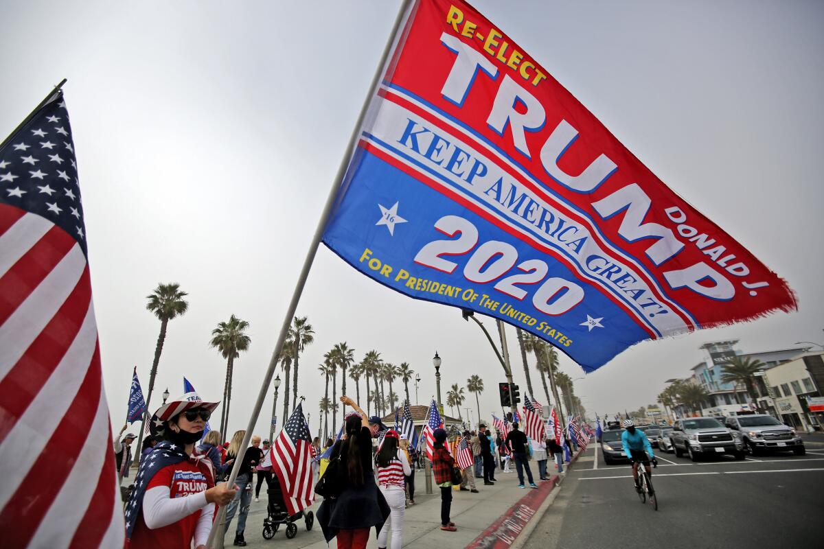Vu Son waves a Trump election flag during an election rally at Huntington Beach Pier on Wednesday.