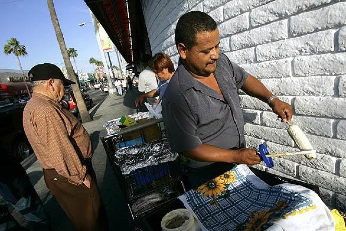 Zambino Garcia serves corn on the cob in East Los Angeles. Los Angeles and other cities have adopted rules regulating street vending following a state law decriminalizing the activity. A similar effort is now underway in Glendale.