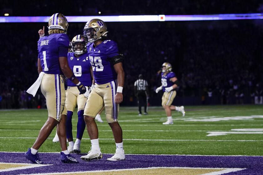 Washington wide receiver Rome Odunze (1) celebrates his touchdown against California with quarterback Michael Penix Jr. (9) and running back Sam Adams II (28) during the first half of an NCAA college football game Saturday, Sept. 23, 2023, in Seattle. (AP Photo/Lindsey Wasson)