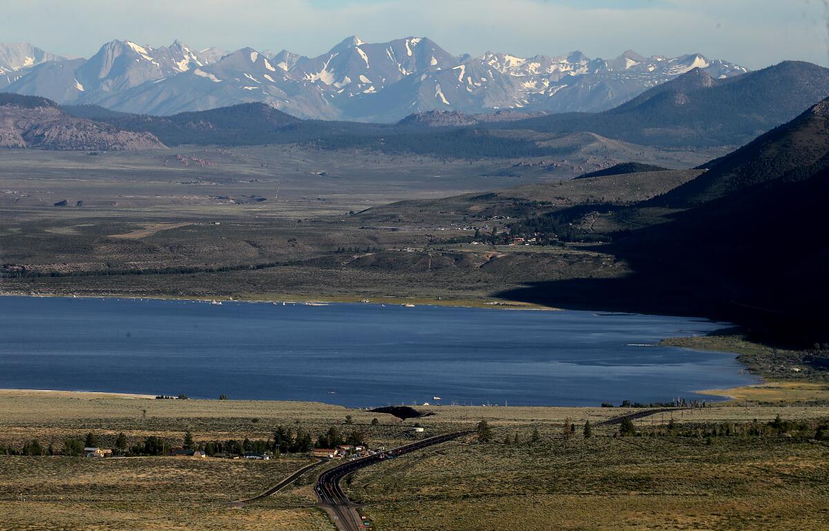 A long-range view of a lake with snowcapped mountains in the background. 