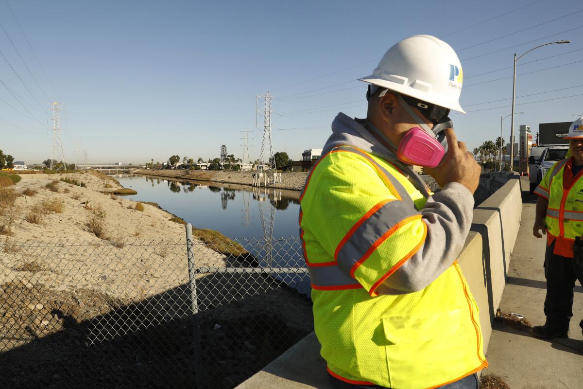 Workers from the Los Angeles county Department of Public Works prepare to work on the situation at Dominguez Channel