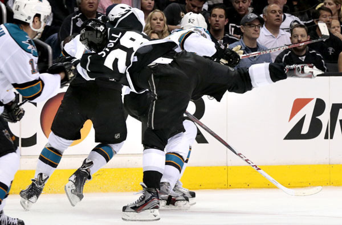 Kings center Jarret Stoll gets knocked off his skates from a hit by Sharks left wing Raffi Torres (hidden from view) in Game 1 of the Western Conference semifinals on Tuesday at Staples Center.