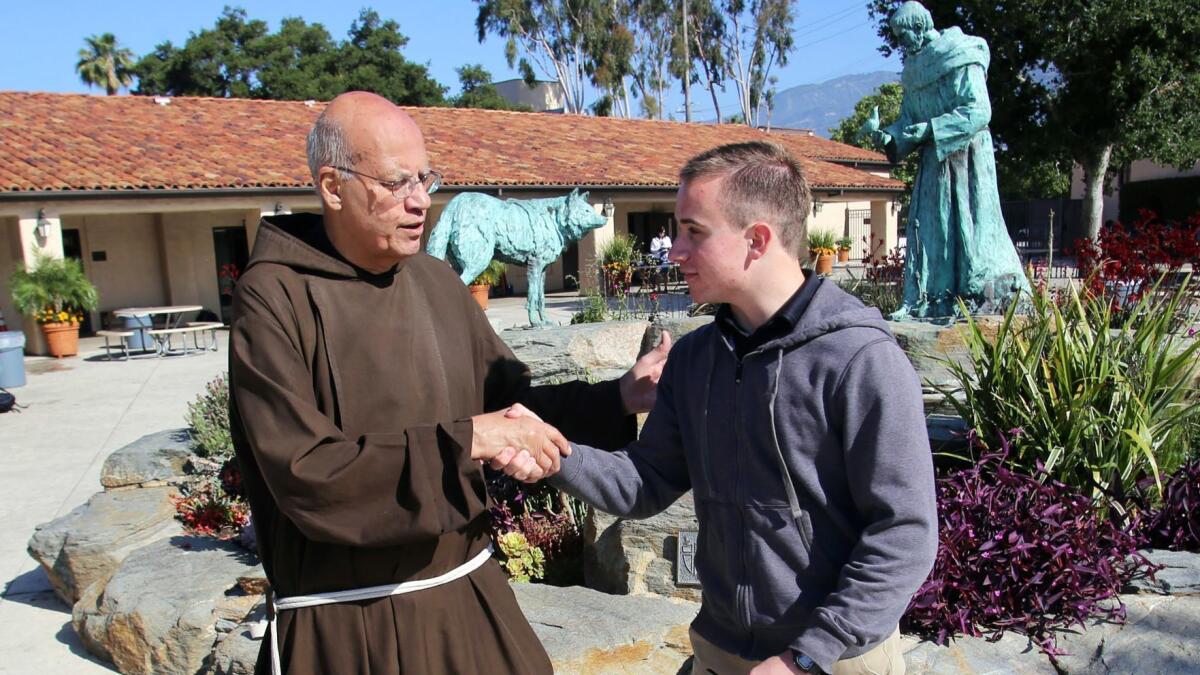 Fr. Tony Marti, president of St. Francis High School, congratulates Danny Bozanic, 17, a junior at St. Francis for receiving the school's first President’s Coin.