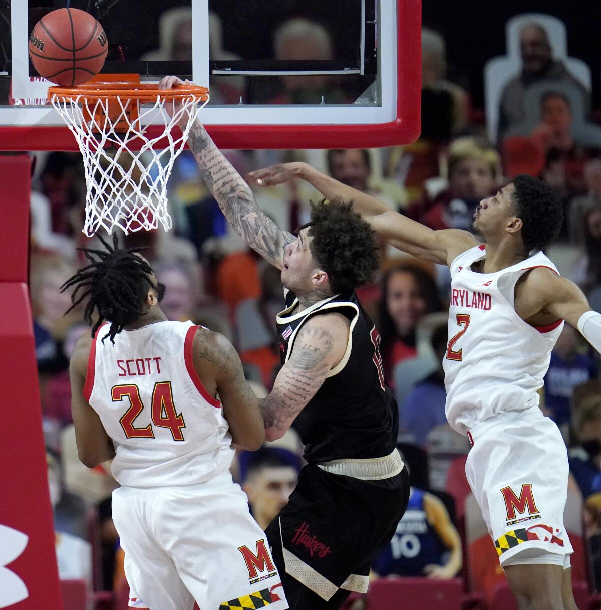 Nebraska guard Teddy Allen, center, goes up for a shot against Maryland forward Donta Scott, left, and guard Aaron Wiggins during the second half of an NCAA college basketball game, Tuesday, Feb. 16, 2021, in College Park, Md. Maryland won 64-50. (AP Photo/Julio Cortez)