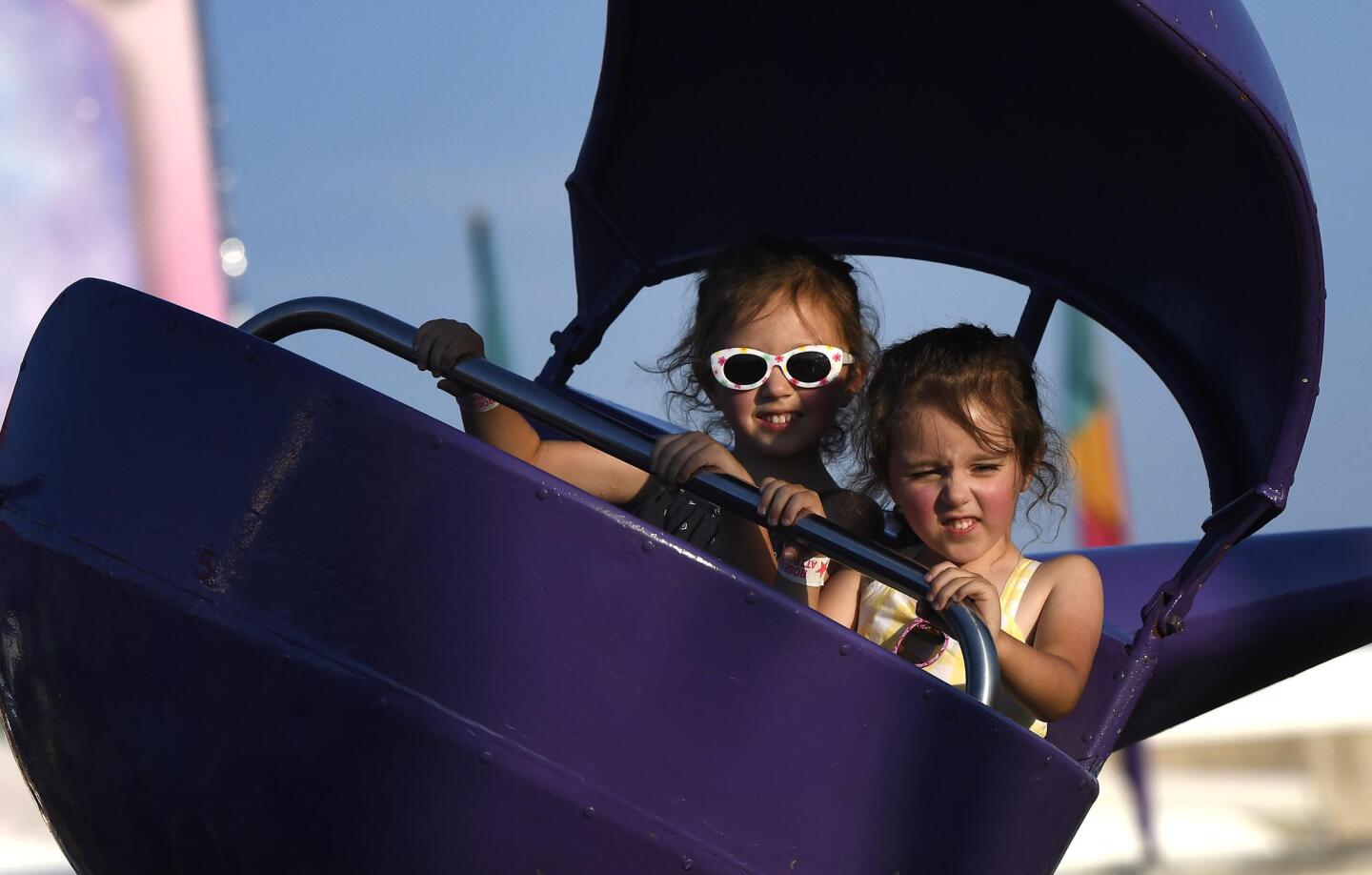 Twins Caroline, left, and Madeline Moore, both 4, of New Windsor, pilot a helicopter ride at the Winfield fire company carnival Wednesday, July 10, 2019.