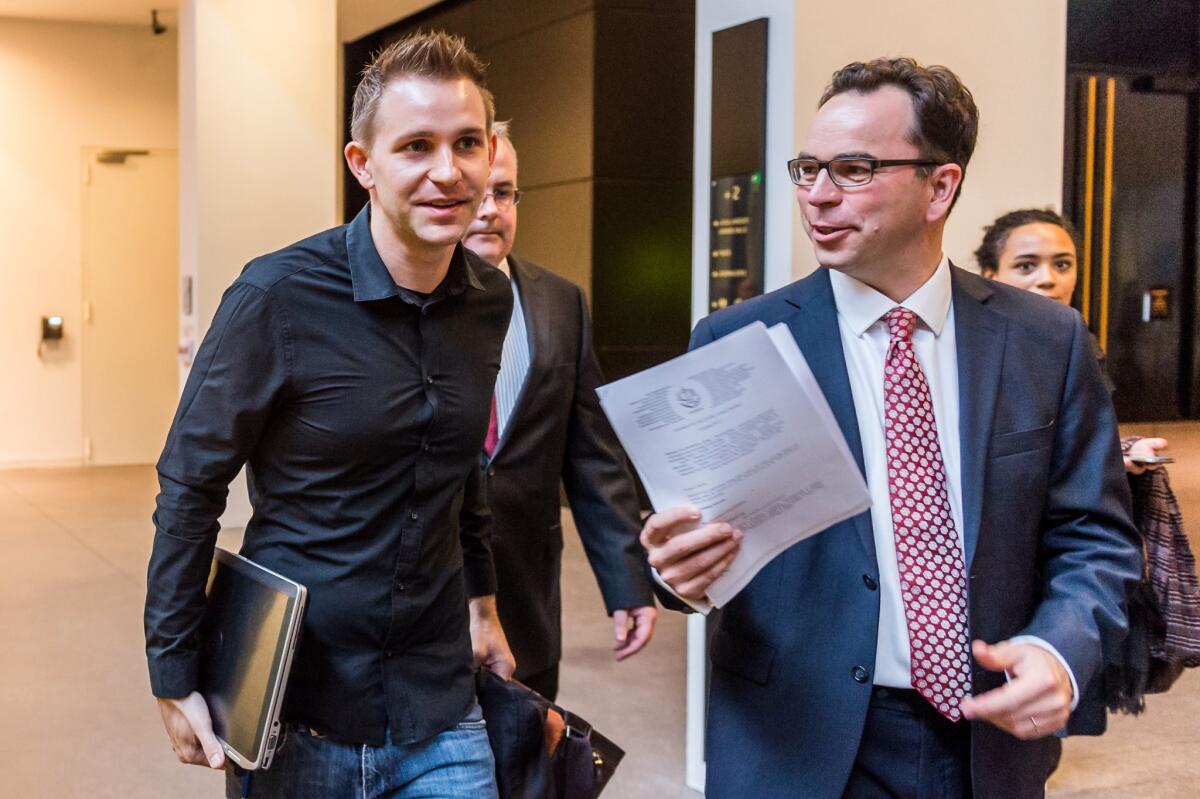 Max Schrems, left, and his lawyer Herwig Hofmann, right, walk in the hallway at the European Court of Justice in Luxembourg on Tuesday.