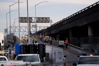 LOS ANGELES CA NOVEMBER 13, 2023 - Crews examine damage at the site of a fire under Interstate 10 in Los Angeles, California. (Eric Thayer / For The Times)